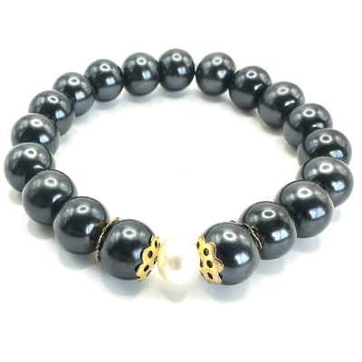 Pulseira elástica com bolas pretas e bola branca central com detalhes dourados