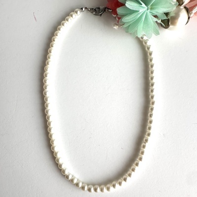 Colar de pérolas brancas com fecho metálico e detalhe decorativo em tecido verde e cor-de-rosa