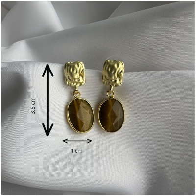 Brincos dourados com pendente oval castanho sobre tecido branco