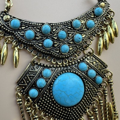 Colar dourado com pedras turquesa e detalhes decorativos