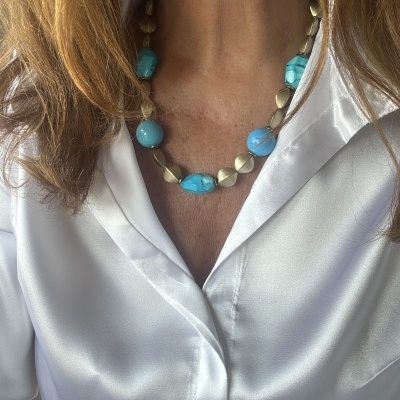 Colar azul turquesa e prateado com blusa branca acetinada