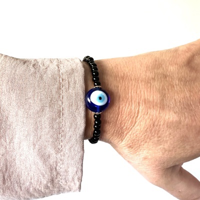 Pulseira com contas pretas e conta central azul padrão olho