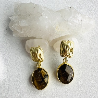 Brincos dourados com pedra oval marrom escura e cristal branco translúcido.