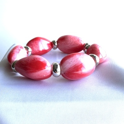 Pulseira elástica com contas ovais vermelhas e brancas com espaçadores metálicos.