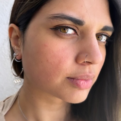 Mulher com brinco de argola, piercing no nariz e colar com pendente de pérola