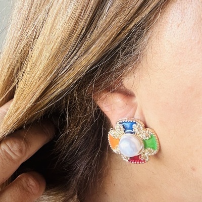 Brinco dourado com pedras coloridas e pérola na orelha
