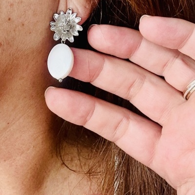 Brinco pendente com flor prateada e pedra oval branca