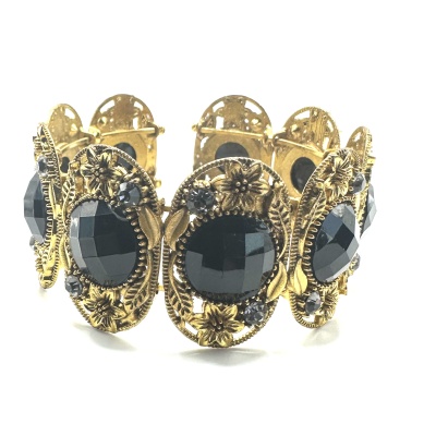 Pulseira dourada com pedras pretas e design floral em fundo branco