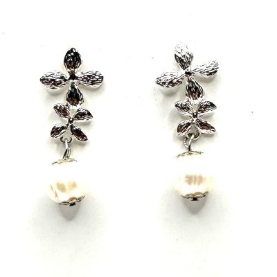 Brincos prateados com flores e pérolas sobre fundo branco