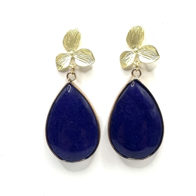 Brincos dourados com pendente azul gota sobre fundo branco.