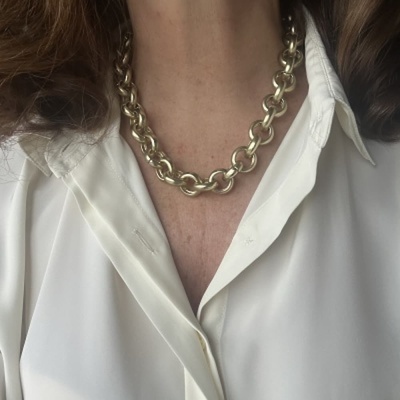 Colar de corrente dourada com elos grossos usado com camisa branca