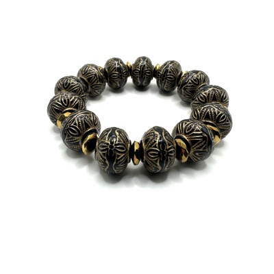 Pulseira elástica com contas pretas e douradas em fundo branco