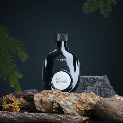 Frasco preto de perfume RIIFFS Masculin Leather sobre pedras e madeira com fundo escuro