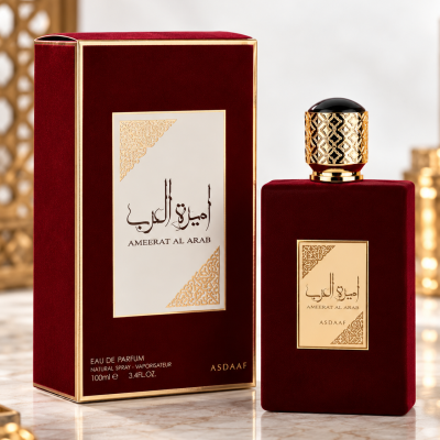 Frasco e caixa de perfume vermelho escuro com detalhes dourados e padrão árabe.