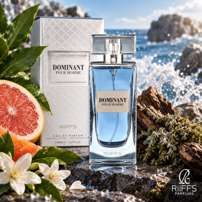 Perfume DOMINANT POUR HOMME em vidro azul com embalagem branca e frutas e flores junto ao mar