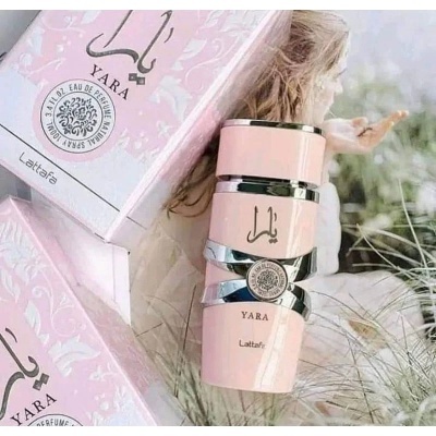 Frasco de perfume YARA rosa com caixa e fundo desfocado