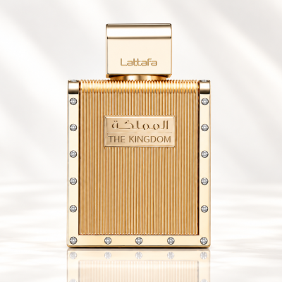 Frasco de perfume dourado com pedras decorativas e texto THE KINGDOM