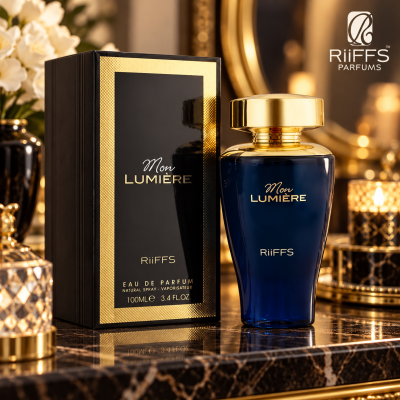 Frasco azul escuro de perfume Mon LUMIÈRE com tampa dourada junto a caixa preta e dourada em superfície de mármore