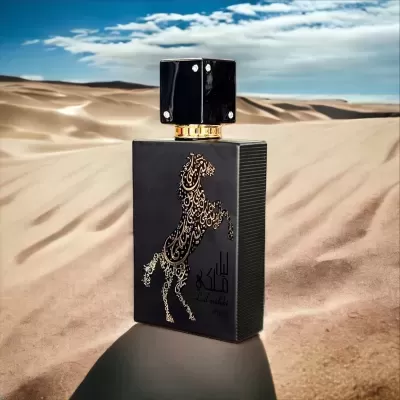 Frasco de perfume preto com desenho dourado de cavalo em relevo numa paisagem de deserto