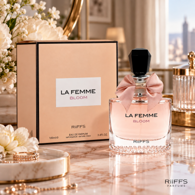 Frasco de perfume LA FEMME BLOOM com embalagem bege e flores brancas ao lado