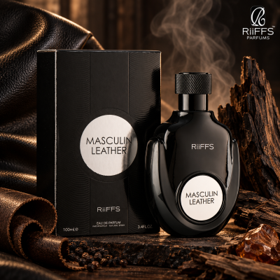 Frasco preto de perfume Masculin Leather da RiiFFS ao lado da caixa preta, sobre superfície com pedaços de couro e madeira.
