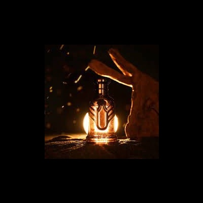 Frasco âmbar de vidro com tampa de botão numa superfície texturizada, iluminado por trás