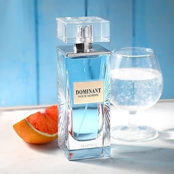 Frasco de perfume azul Dominant Pour Homme com fatia de toranja e copo de água