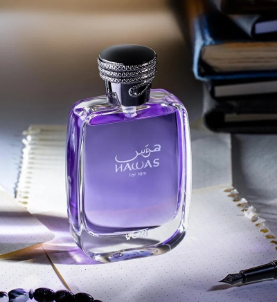 Frasco de perfume HAWAS For Him roxo com tampa prateada em papel com caneta e livros