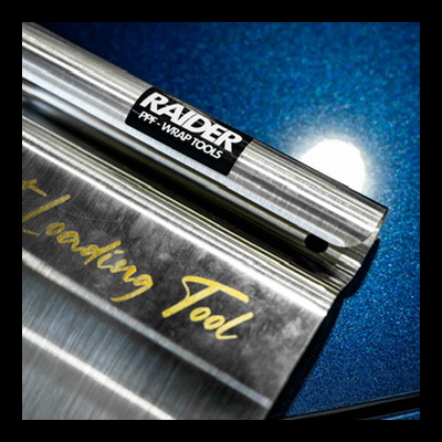 Ferramenta metálica prateada com etiqueta 'RAIDER PPF WRAP TOOLS'