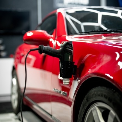 Carro desportivo vermelho com ferramenta de polimento preta na porta dianteira em espaço interior