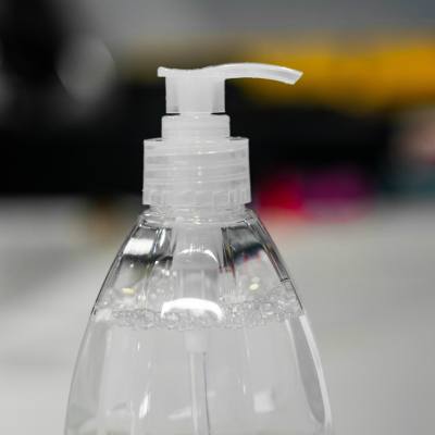 Frasco plástico transparente com dispensador branco e líquido claro com bolhas.