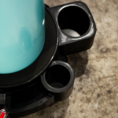 Suporte preto de plástico com recipiente azul claro numa superfície de pedra.