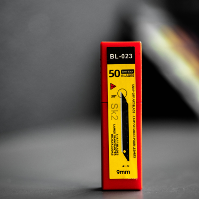 Embalagem vermelha e amarela de lâminas com texto 'BL-023' e '50 BLADES'