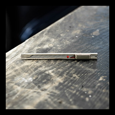 Cortador de precisão metálico prateado numa superfície de madeira escura