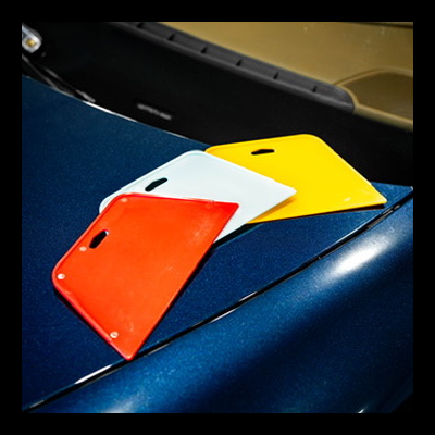 Placas de plástico vermelha, branca e amarela sobre carro azul