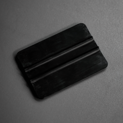 Aplicador de plástico preto para vinil sobre superfície cinza