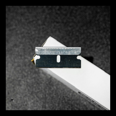 Lâmina de barbear metálica sobre caixa branca