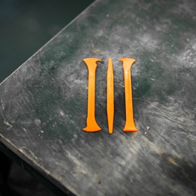 Três ferramentas de plástico laranja sobre superfície escura rugosa