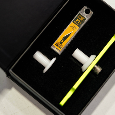 Caixa preta com embalagem de lâminas hobby #11 e duas peças brancas