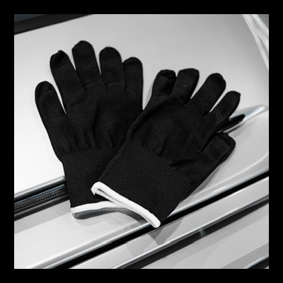 Luvas pretas com punhos elásticos brancos sobre superfície cinza