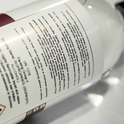 Frasco branco com rótulo com texto em inglês sobre produto de limpeza química