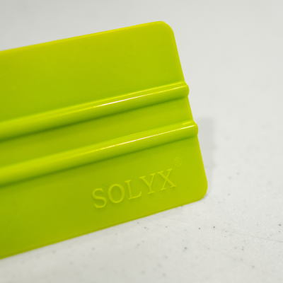 Espátula verde de plástico com marcação SOLYX.