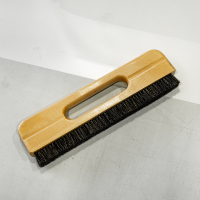 escova de madeira com cerdas pretas sobre superfície cinzenta