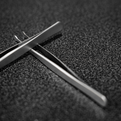 Prendedores de metal prateado sobre superfície preta rugosa