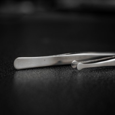 Pinça metálica prateada sobre superfície escura texturizada