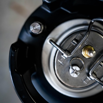 Cafeteira de pressão em aço inox e plástico preto vista de cima.