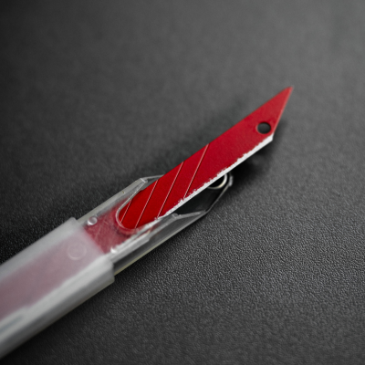 Lâmina de estilete vermelha numa estrutura plástica transparente