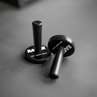 Dois carimbos de borracha pretos com texto RAPI em mesa cinzenta