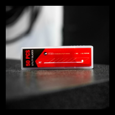 Embalagem de estiletes utilitários com rótulo vermelho e preto