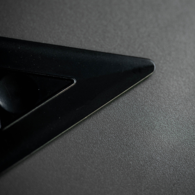 Canto de objeto triangular preto sobre superfície cinza texturizada